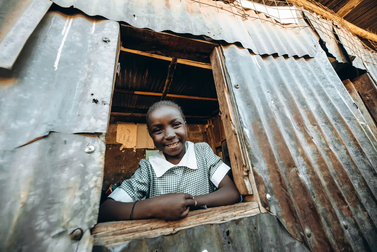Girl at the window of her school in TASIA Slums -Beyond the Vision Community sch