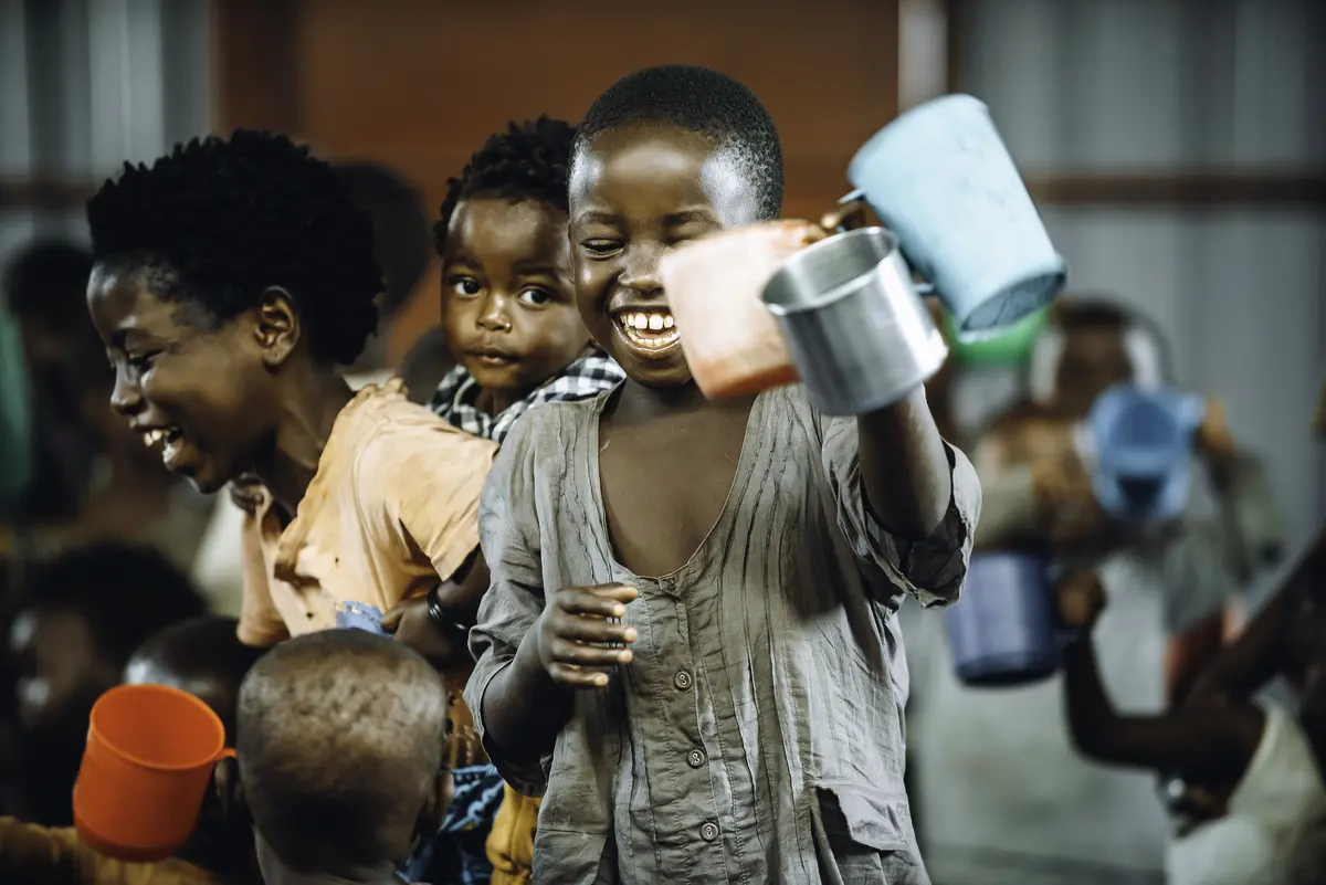 Children smile as they receive porridge at a rescue center in Goma, Congo.