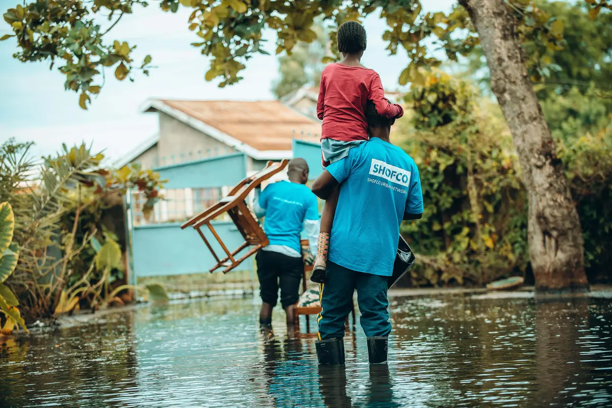 SHOFCO staff rescuing a child from a flooded home in Kisumu.
